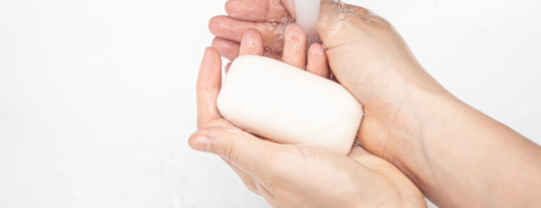 Pessoa lavando as mãos com um sabonete branco